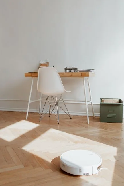 who-we-are Une paire de personnes range des cartons étiquetés dans un salon minimaliste, en vue du jour du déménagement.